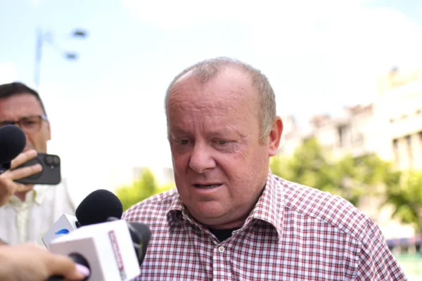 Bărbat intervievat de jurnaliști în aer liber